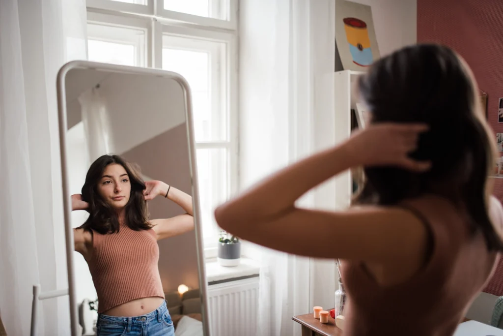 Une jeune fille qui se regarde dans un miroir