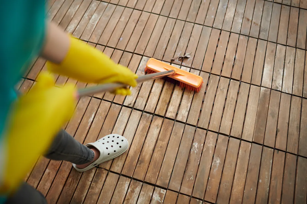 Une femme avec un balais qui nettoie une terrasse