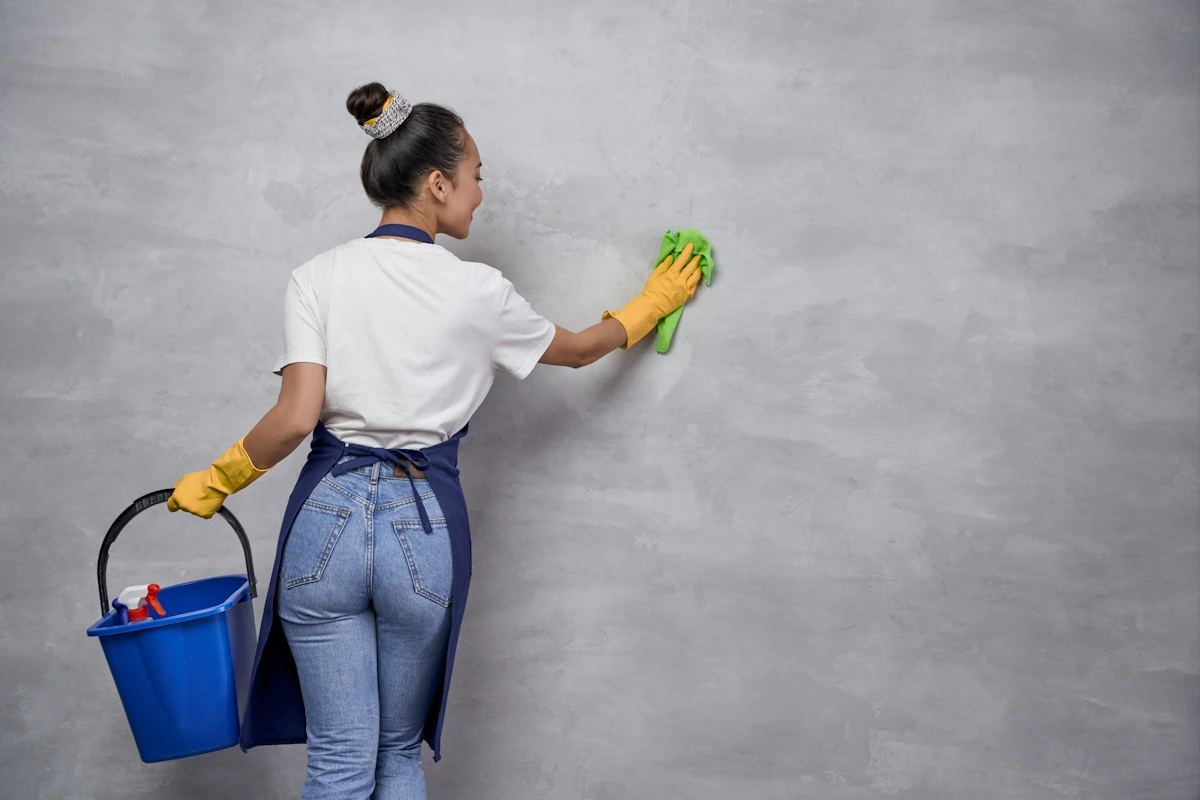 Une femme qui nettoie un mur