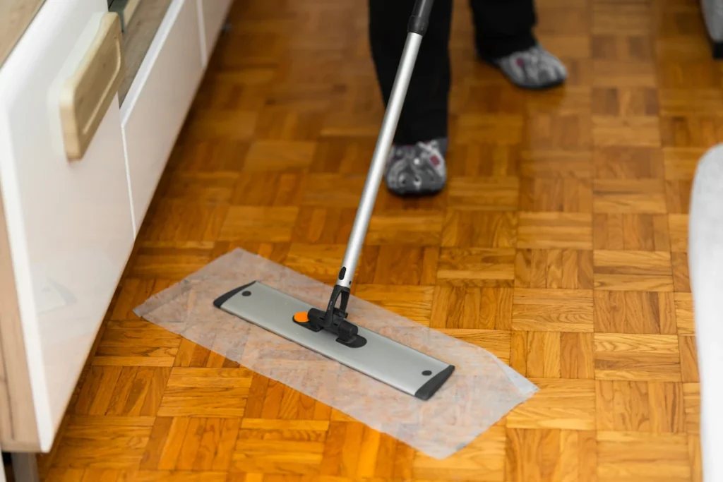 une personne qui nettoie le sol en bois