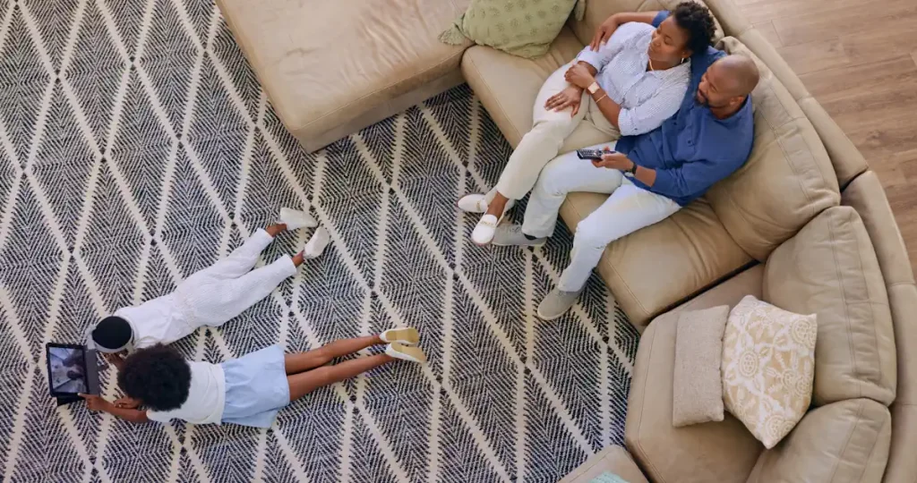 Une famille dans un salon avec un tapis sur le sol