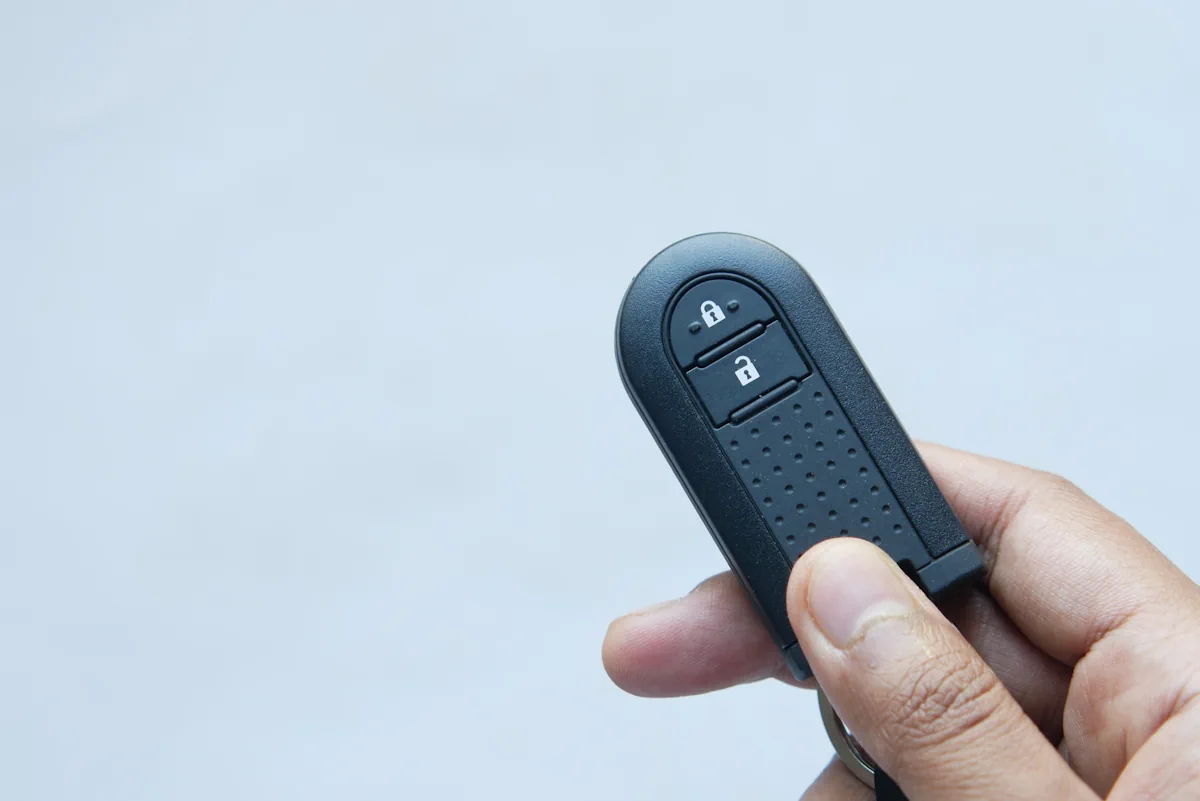 Une personne qui tient une petite télécommande noire dans sa main