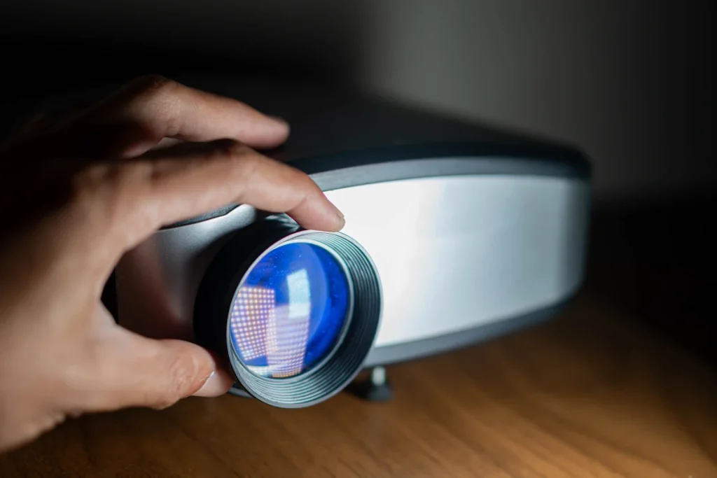 Une main qui règle un Vidéoprojecteur pour salle de cinéma