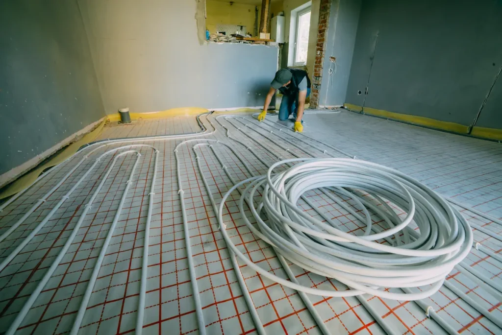Un homme qui installe un plancher cghauffant
