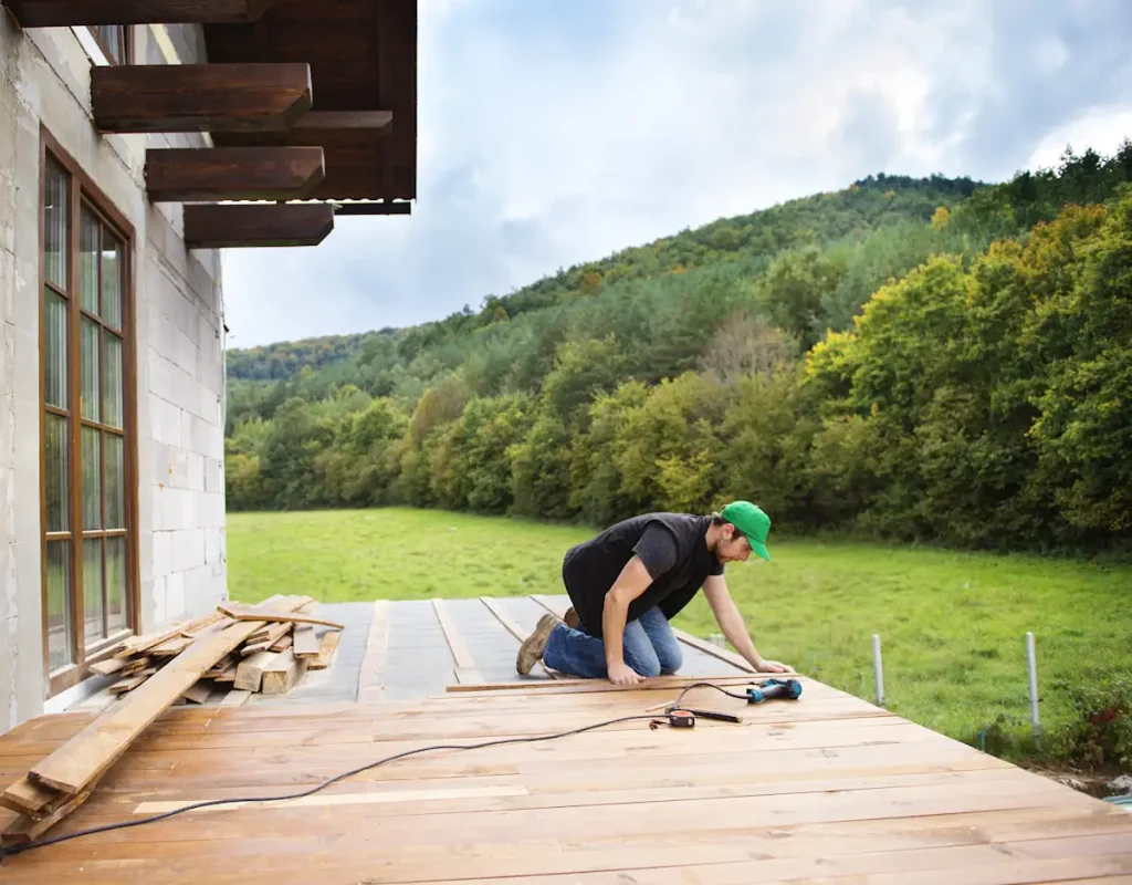 Un homme qui installe une terrasse en bois