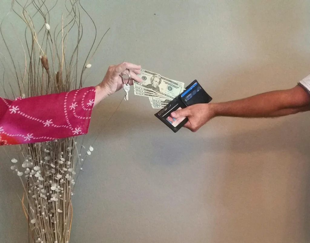 Une personne qui prend de l'argent dans le portefeuille d'une autre en tenant une clé