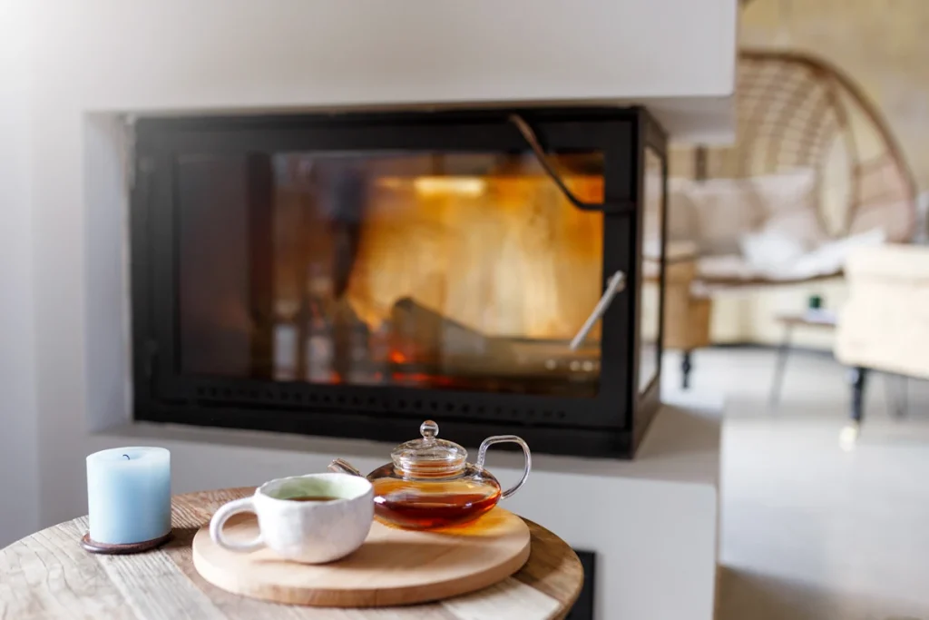 Une poêle de chauffage devant une table avec une tasse de thé