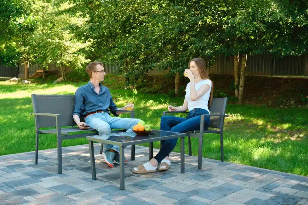 Une femme et un homme bien installés dans un salon de jardin