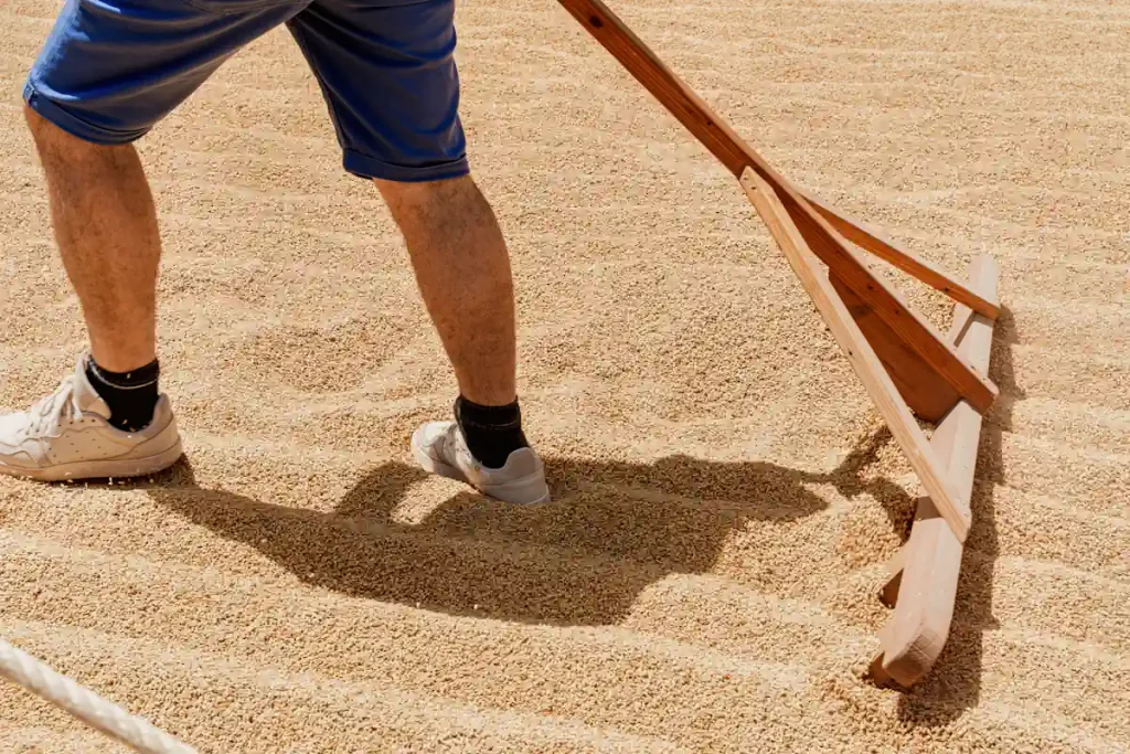 Un homme qui mélange du sable avec un accessoire en bois