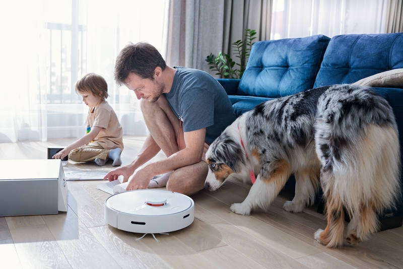 famille avec un chien et un aspirateur robot