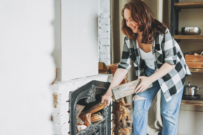 femme qui met du bois dans sa cheminée