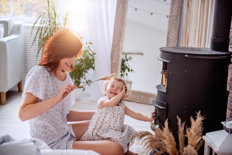 maman et son enfant devant le poêle à bois