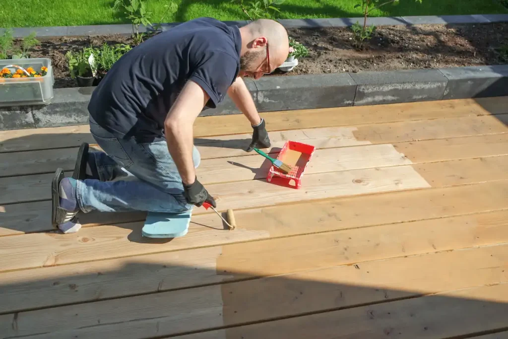Une personne qui applique huile terrasse bois exterieur