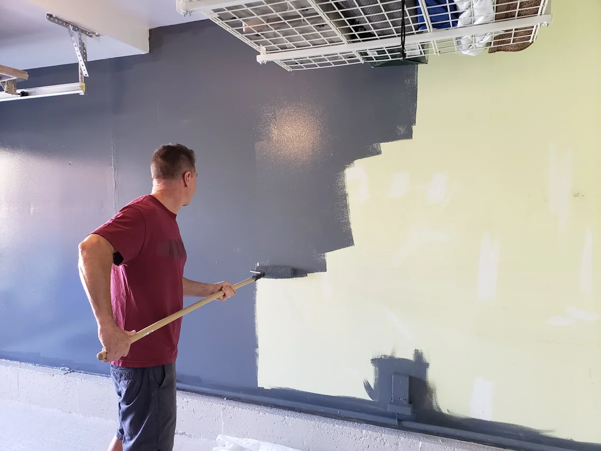 Un homme qui peint un mur de garage