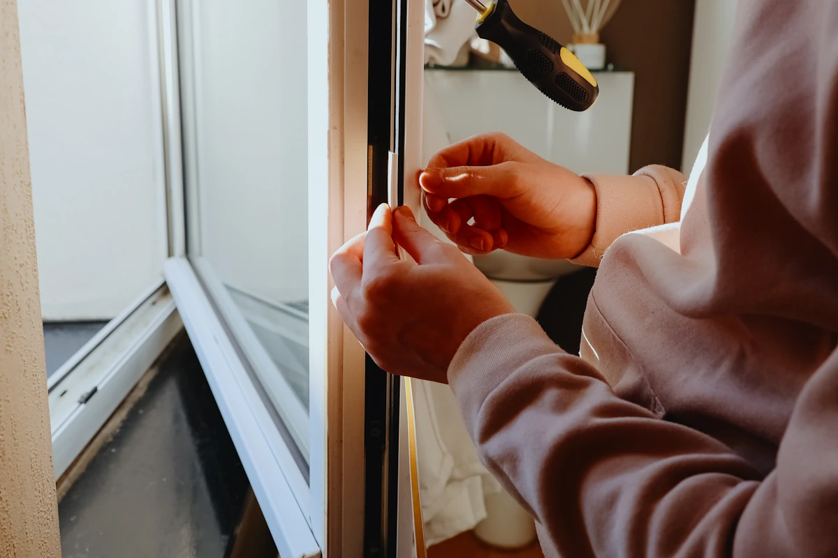 Un homme qui regarde les joints d'une fenêtre pvc