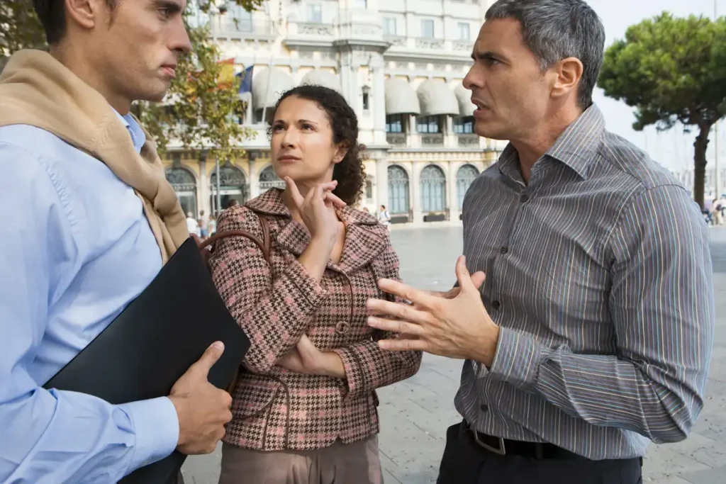 Une femme et deux homms qui discutent ensemble du problème de nuisances sonores de murs mitoyens