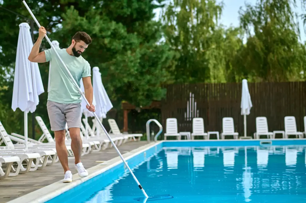 Un homme qui nettoie une piscine