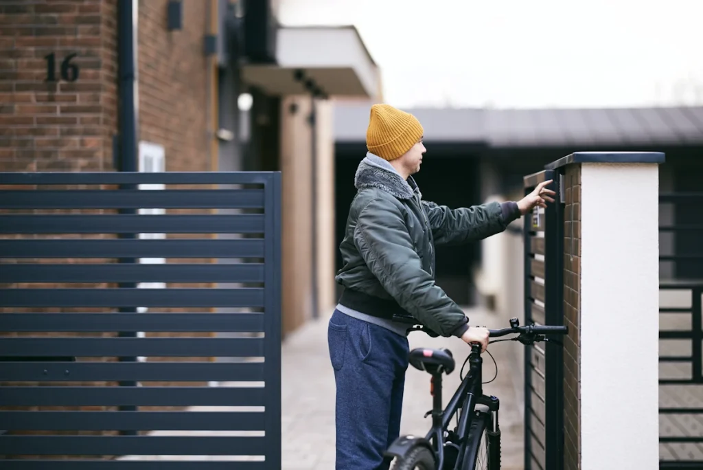 Un homme qui regarde les gonds d'un portail battant