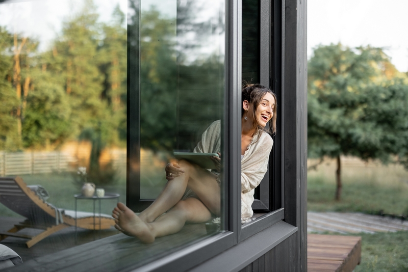 femme qui regarde par sa baie vitrée